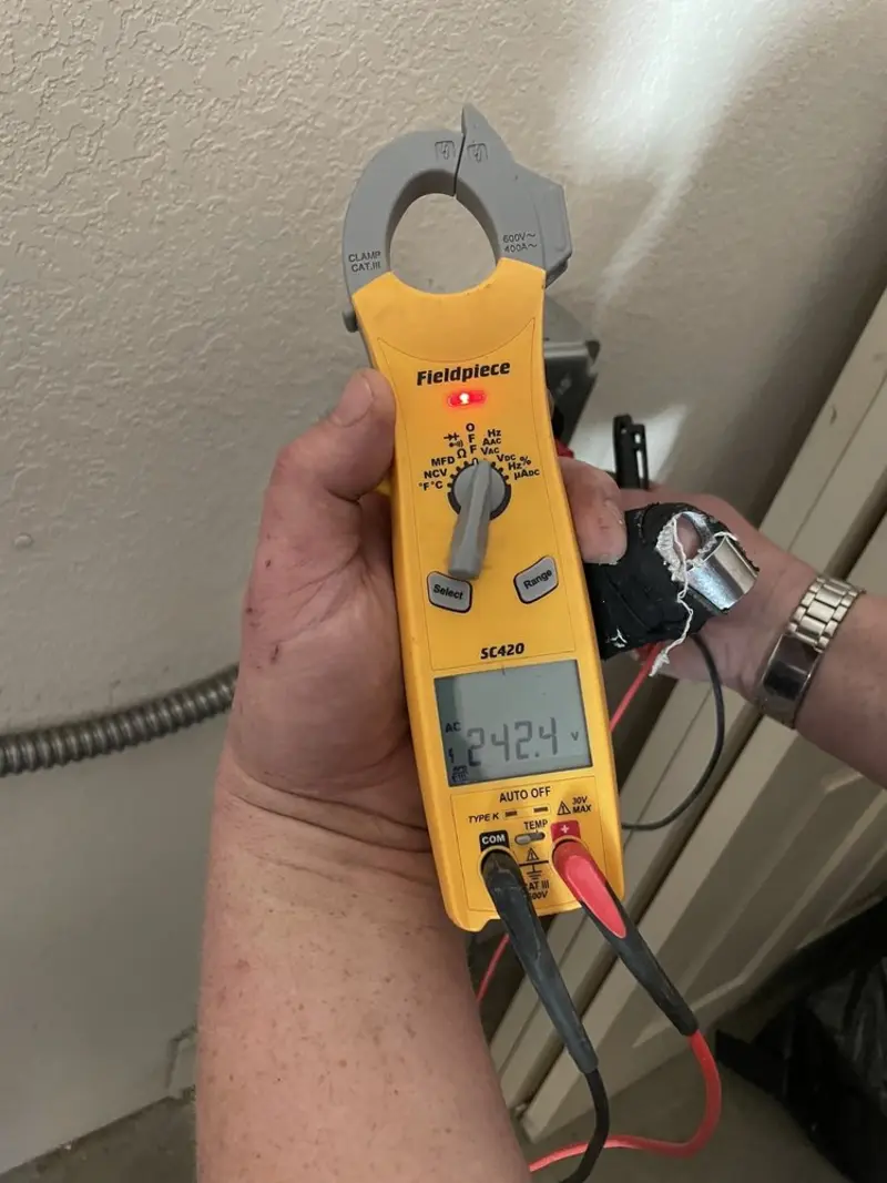 Voltage testing with clamp meter during Whole House Surge Protector in Smithville-Sanders
